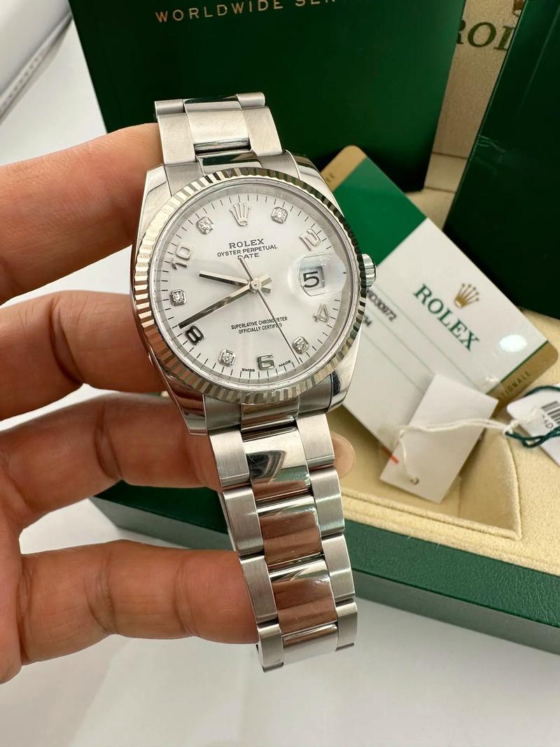 Close view of a silver-tone watch with a fluted bezel and metal bracelet.