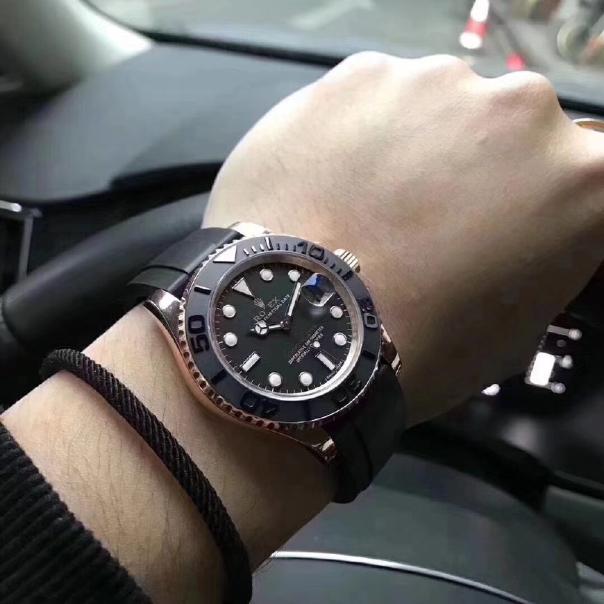 A dark-dial watch on a wrist, showing the case, crown and strap.
